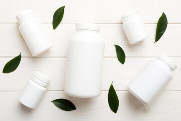 supplement pills with medicine bottle health care and medical top view. Vitamin tablets. Top view mockup bottle for pills and vitamins with green leaves, natural organic bio supplement, copy space