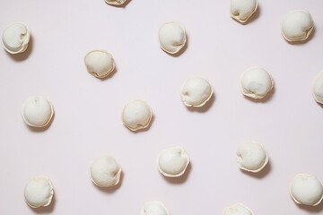 Flat lay of frozen dumplings arranged on neutral surface.