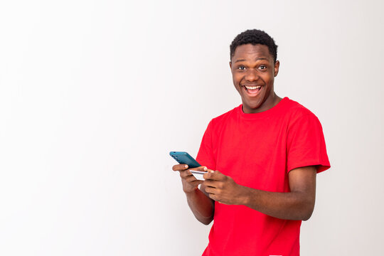 black man using his phone and credit card feeling excited