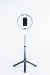 Ring light with smartphone mounted on a tripod stand, isolated on a white background. 3D Rendering