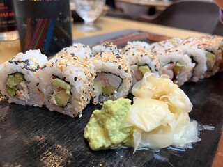 Close up sushi roll on black plate in Japanese restaurant