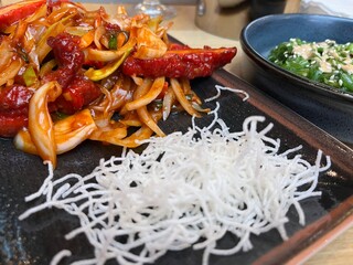 Sliced chicken fillet with hot garlic sauce with vegetables and fried glass noodle 