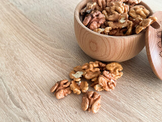 Walnuts kernels on dark desk with color background, Whole walnut in wood vintage bowl.
