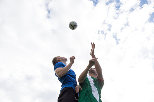 Football players jumping to head the ball during a football match