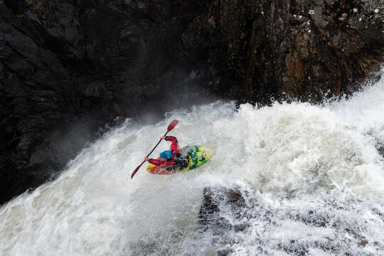 Man kayaking on waterfall on river