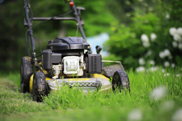 Lawn mover on green grass in modern garden. Machine for cutting lawns.