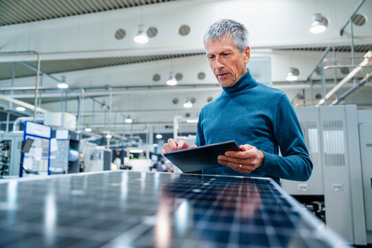 Businessman using tablet PC at factory