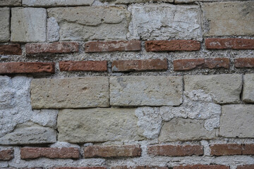 Textured wall of a historical building in Albania showcases a blend of stone and brick materials from a bygone era