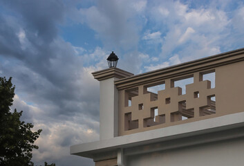 Architectural details of a modern building in Albania featuring a decorative exterior and a lamp on top of the wall