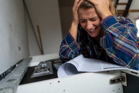Despaired young woman with assembly instructions