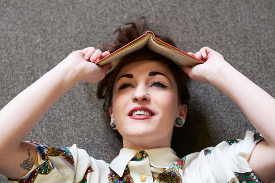 Female student reading book in a public library