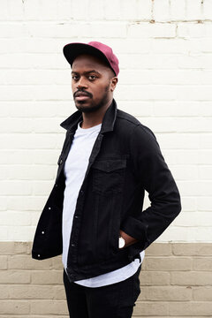 Portrait of mid adult man wearing denim jacket and basecap