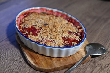 The dessert is freshly baked, with juicy, bubbling fruit filling visible beneath the crunchy...
