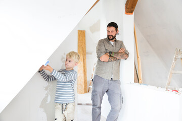 Father and son working on loft conversion using water level
