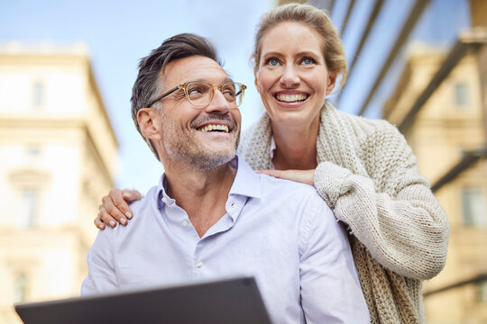 Happy couple using tablet in the city