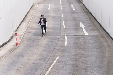 Businessman running on road with arrow signs