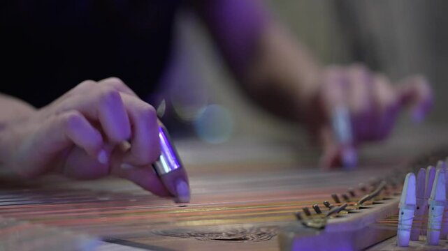 Close-up of a woman's hands playing the qanun (kanon), a traditional Armenian musical instrument. A talented musician expresses creativity by playing a unique instrument․  Middle Eastern music․ 