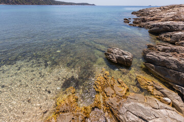 Stunning rocky shoreline in Thassos, Greece, featuring crystal-clear waters and tranquil seascapes.