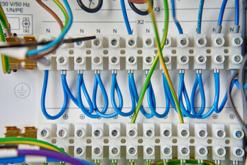 Colorful wires and components connected to terminal block in distribution box. Electrical circuit...