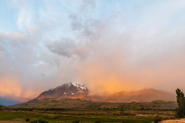 Fototapeta premium Early morning sunrise over Torres Del Paine national park in Patagonia, Chile, highlighting dramatic colours and a rainbow.
