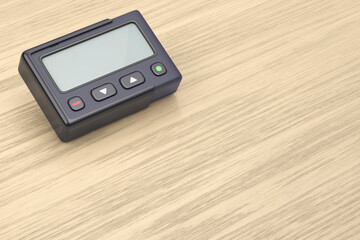 Fototapeta premium Retro pager with blank screen on wooden desk
