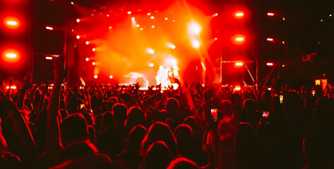 Crowd at concert. Stage lights and hands in the air. People enjoying the party. Fans enjoying music festival.