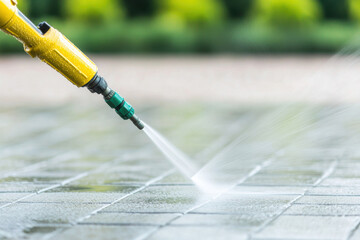 High-pressure cleaning of outdoor surfaces with a pressure washer.