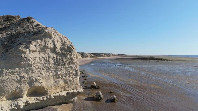 Aerial shot of El Ca&ntilde;ad&oacute;n de las Ostras on the coast of the Argentinian Sea on a clear morning with a deep blue sky.