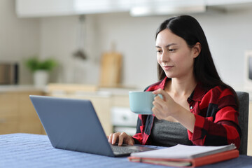 Asian student using laptop e-learning at home