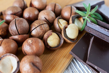 Macadamia nuts with chocolate and rosemary on a wooden board