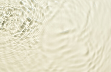 Natural background of water in summer. Beige surface. Clear water with ripples and splashes. water waves in sunlight The water surface has waves.