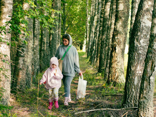 mother and daughter picking mushrooms in the forest
