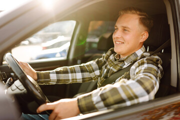 Happy man feeling comfortable sitting on driver seat in his new car. Car travel, lifestyle concept....