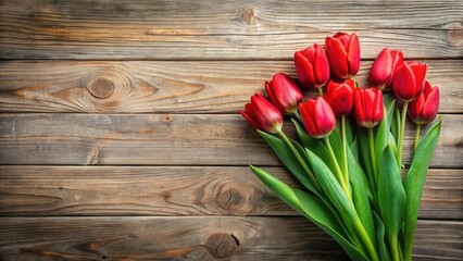 A vibrant bouquet of crimson tulips rests elegantly on a rustic wooden surface, creating a captivating display of springtime blossoms and natural textures.