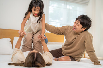 Fototapeta premium Portrait of enjoy happy love asian family father and mother holding hug cute little asian girl child smiling play and having fun moments good time, care, kid, support, insurance, child, at home