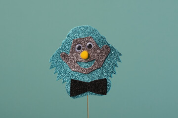 A fun and creative clown with glittery materials, showcasing a cheerful expression and googly eyes. Festive party props. glitter, festive atmosphere. Purim day concept.