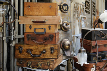A neat stack of old, wooden, brass-handle suitcase boxes for sale in the flea market of Old Tel...