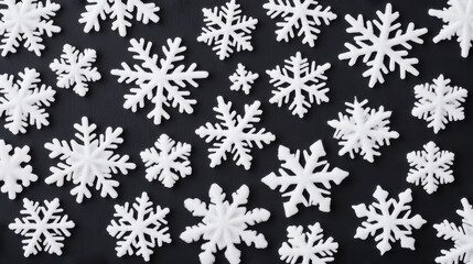 White snowflake decorations arranged on a dark black background in a pattern