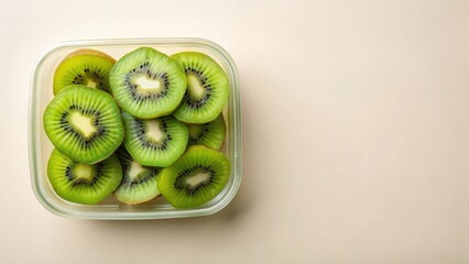 Sliced Kiwi Fruit in a Clear Container on a Beige Background, Ready for a Healthy Snack or Dessert