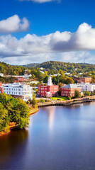 Fototapeta premium Picturesque Waterfront Town Nestled Along a Serene River with Scenic Buildings under a Cloudy Blue Sky.