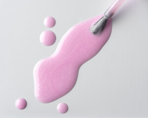 Close-up of pink shimmer nail polish spilling