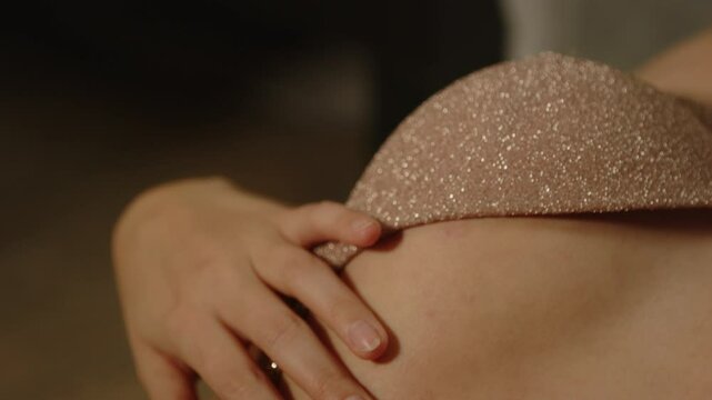 Sensual close up of a hand caressing the brassier of a woman dressed in sexy lingerie