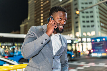 Businessman talking on smartphone in city at night