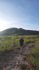 mulher caminhando em area de lavrado e montanhas em roraima