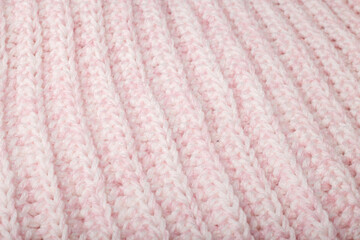 Light pink woolen knitting braid pattern texture, knitted background. Abstract sweater surface, crocheted yarn