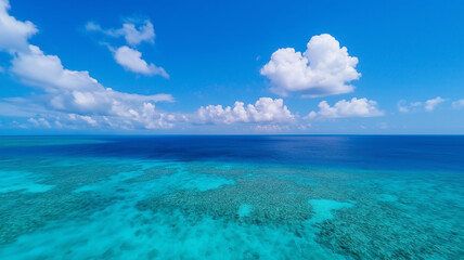 Aerial view of vibrant turquoise ocean with coral reefs and fluffy clouds. serene landscape evokes sense of tranquility and natural beauty