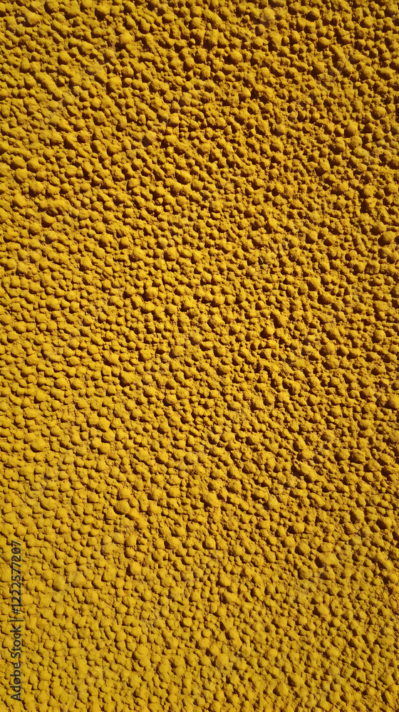 Poster close-up of textured yellow surface shows bumpy and uneven patterns in detail with vivid colors