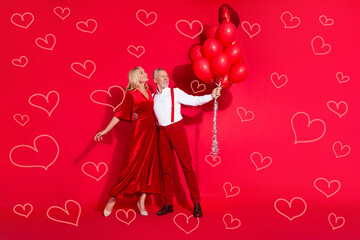 Full length photo of senior husband wife dream look empty space birthday air balloons isolated over red color background