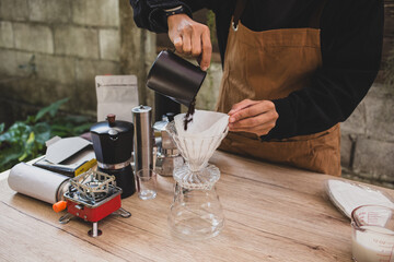 barista prepares pour-over coffee, pouring fresh grounds into a filter homemade brewing process experience craftsmanship precision love for specialty coffee.
