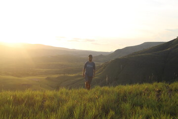 homem com montanhas ao fundo na golder hour